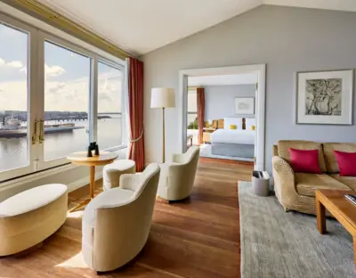 Chambres et suites Chambre avec vue sur l'eau et un lit au premier plan.