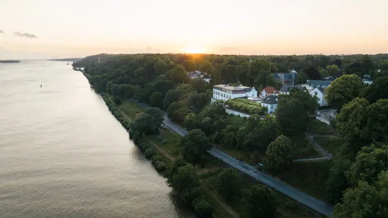 Offres et forfaits Un plan d'eau avec des bâtiments et des arbres en arrière-plan