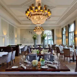 Restauration Une pièce avec des tables, des chaises et des lustres.